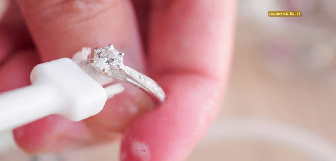 Cara membersihkan cincin emas putih dengan sikat lembut.