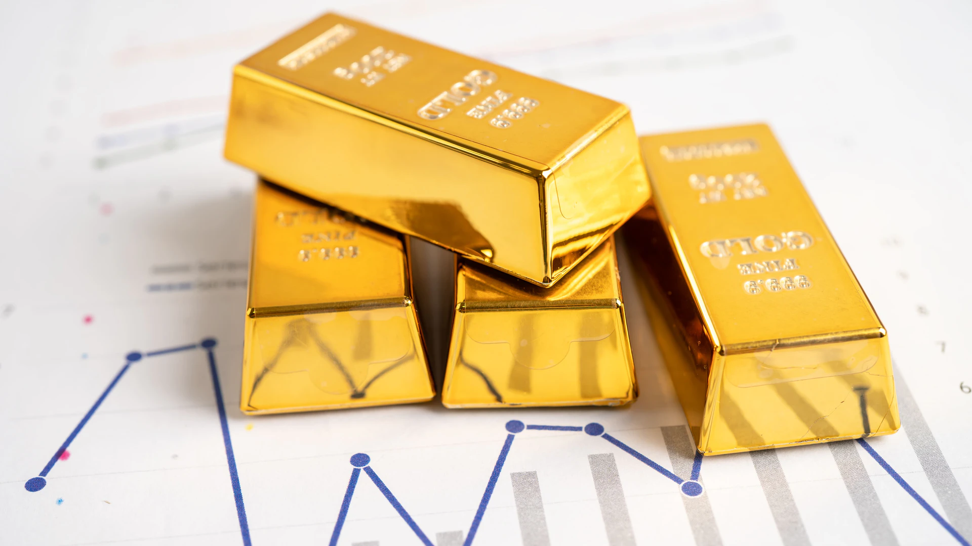 Batangan emas dengan grafik ekonomi dan konsep investasi dengan latar belakang putih